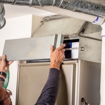 Gallagher's Plumbing, Heating, and Air Conditioning - Technician Repairing Furnace